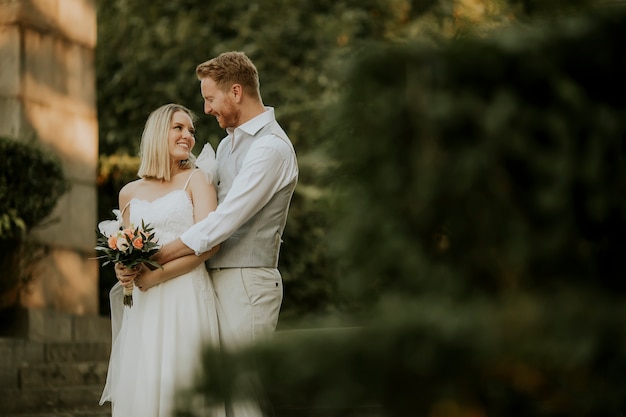 Cute young newlywed couple standing in the park