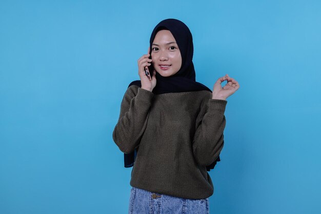 Cute young pretty woman calling by mobile phone wearing hijab