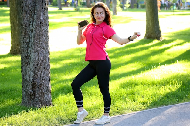 Cute young sporty girl listening to music on a walk