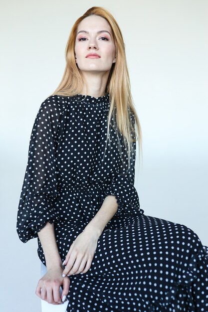 Cute young woman in black polka dot dress