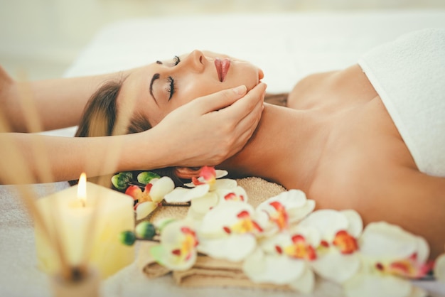 Photo cute young woman enjoying in head massage with her eyes closed.