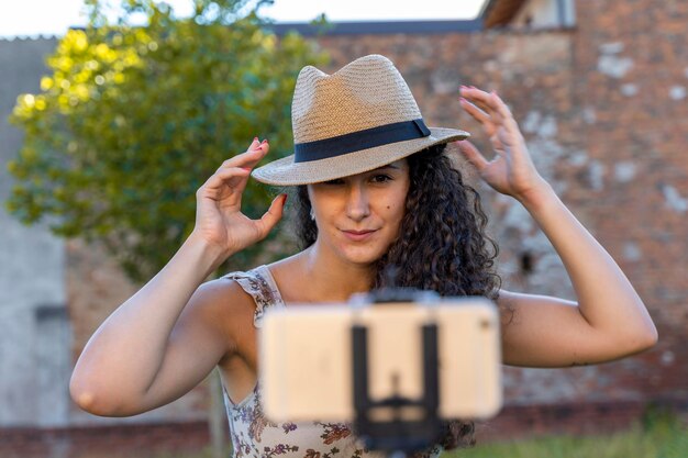 Photo cute young woman getting ready to talk and record a video in front of the smartphone