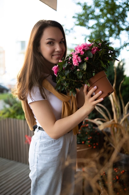 Cute young woman holding her favorite flowers in a street garden shop