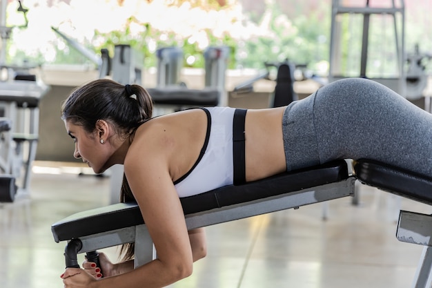 Cute young woman during a leg workout in a gym