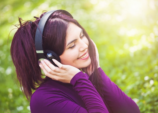 Foto musica d'ascolto sveglia della giovane donna con le cuffie