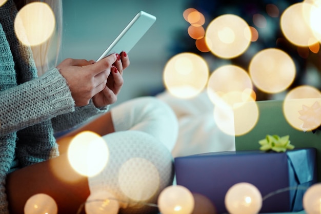 Cute young woman's hands using tablet   during cozy Xmas holidays at home.