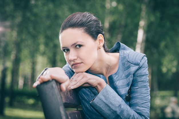 Cute young woman sitting on a Park bench