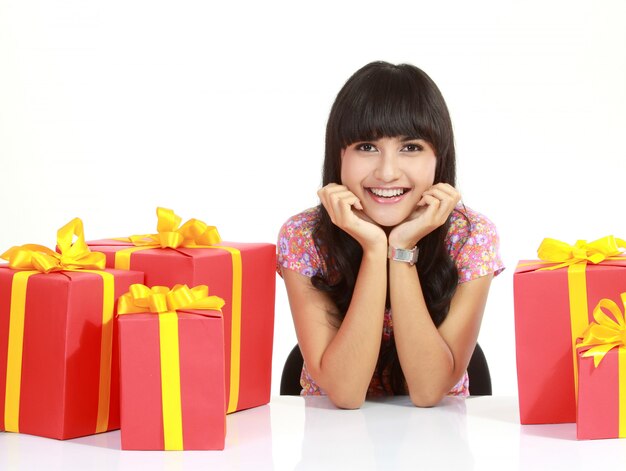 Cute young woman surrounded by packages, isolated