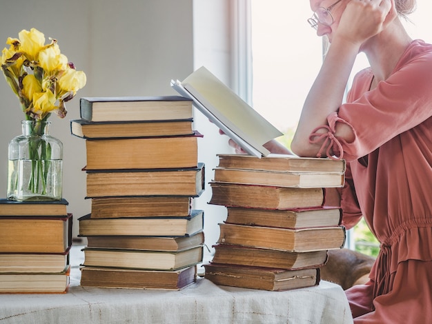 Cute, young woman and vintage books. Close-up, isolated background. Studio photo