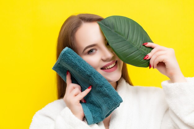 Cute young woman wipes the face towel after taking a shower