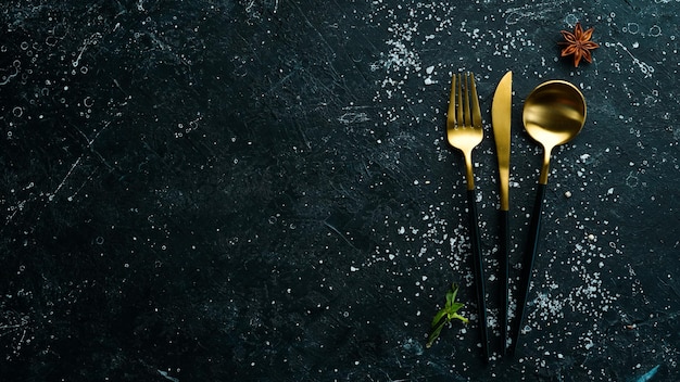 Cutlery on a black stone background Top view Free space for text