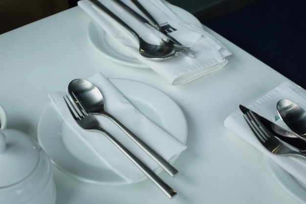 Cutlery and empty plate on white background