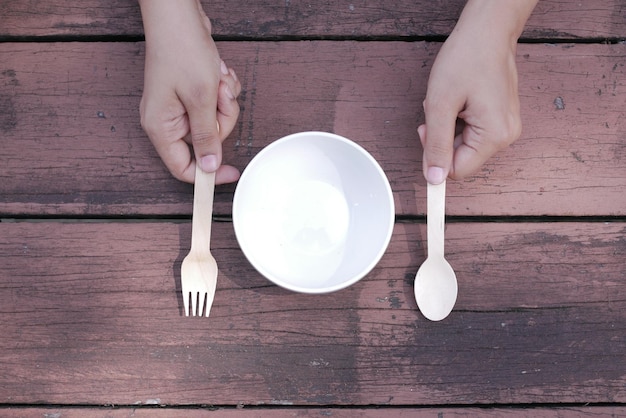 Cutlery and empty plate on wooden background top down