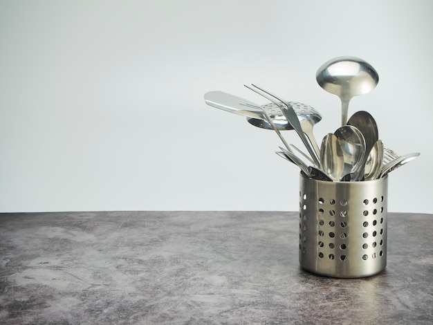 Cutlery holder, stainless steel on table against the white background