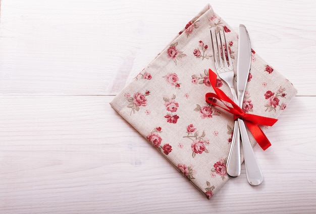 Cutlery and napkin on wooden desk