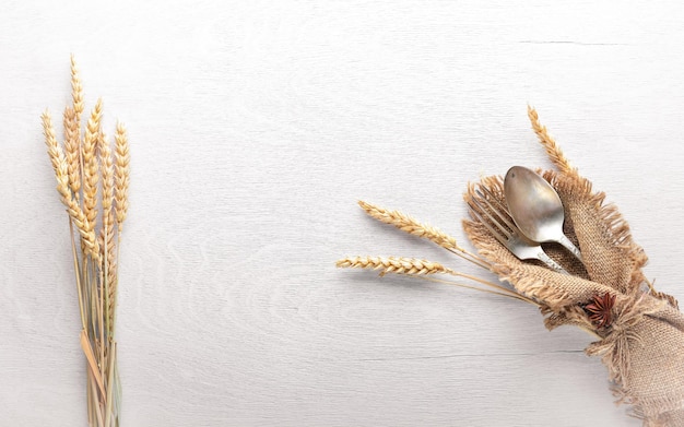 Cutlery spoon and fork in old fabric on Wooden background Top view Free space