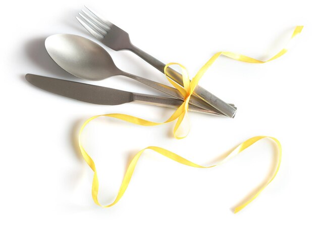 Cutlery tied with ribbon on light background