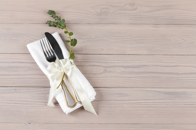 Cutlery wrapped in a napkin on a wooden table