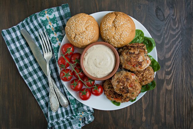 소스와 함께 하얀 접시에 그릇에 파프리카, 토마토와 허브 다진 고기 cutlets