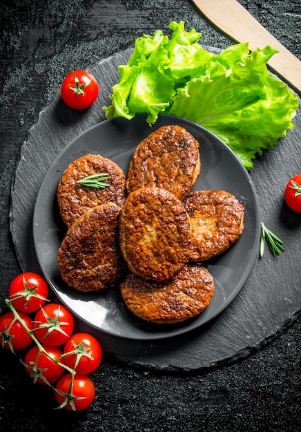 사진 샐러드 잎과 토마토를 곁들인 접시에 커틀릿