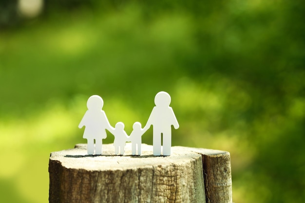 Cutout family on stump on blurred background