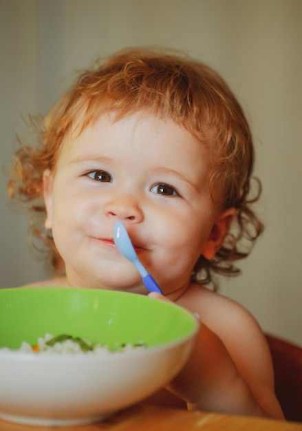 Cutr baby child eating himself with a spoon