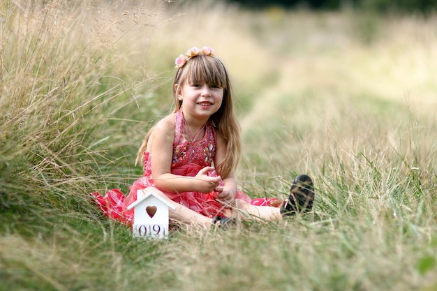 cutr little girl in a dress near the field