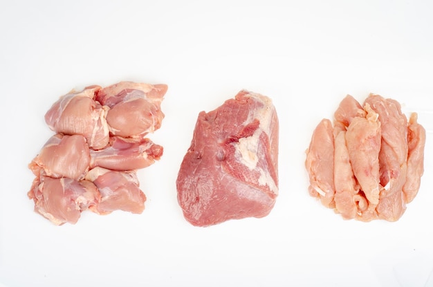 Фото Отрубы мяса нарезки различных частей курицы, изолированные на белом фоне. студийное фото