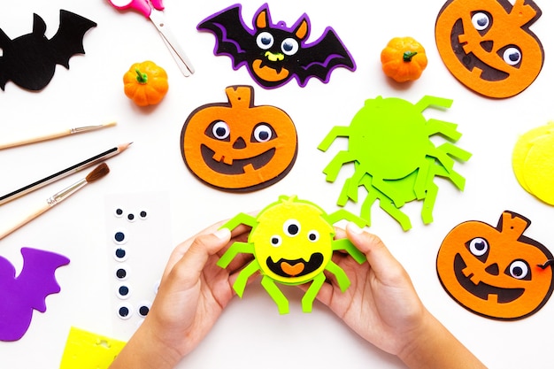 Cuts of paper for Halloween. Hand cut paper. Pumpkins. Scissors and glue. On a light background. Top view. Flat lay. DIY.