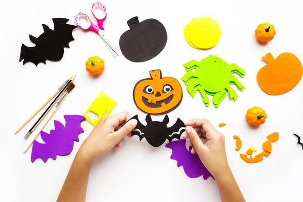 Cuts of paper for Halloween. Hand cut paper. Pumpkins. Scissors and glue. On a light background. Top view. Flat lay.