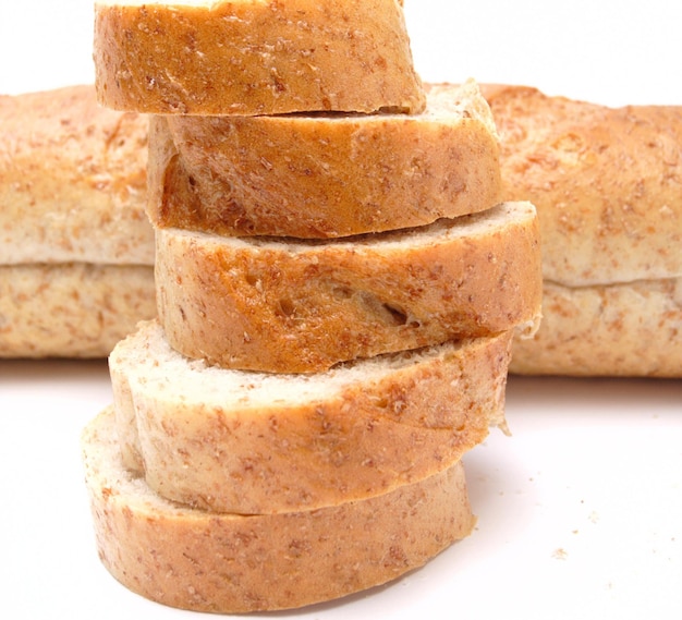 Cutted long loaf with bran on the white background