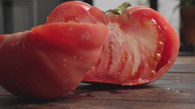 大きなジューシーなトマトを切る