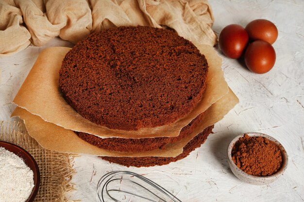 Cutting the biscuit into layers Slicing chocolate sponge cake at home in the kitchen