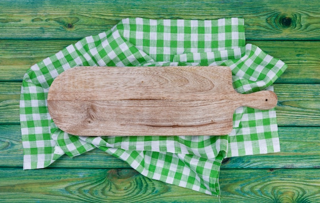 Cutting board on green checkered tablecloth