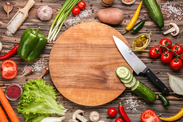 Photo cutting board and vegetables on wooden background