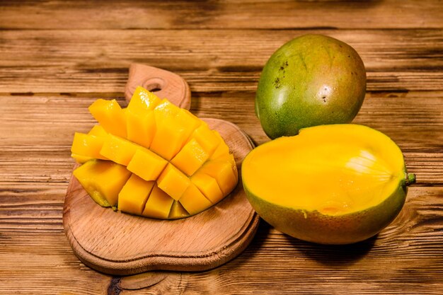 Cutting board with chopped mango fruit on rustic wooden table