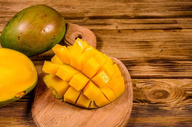 Cutting board with chopped mango fruit on a wooden table