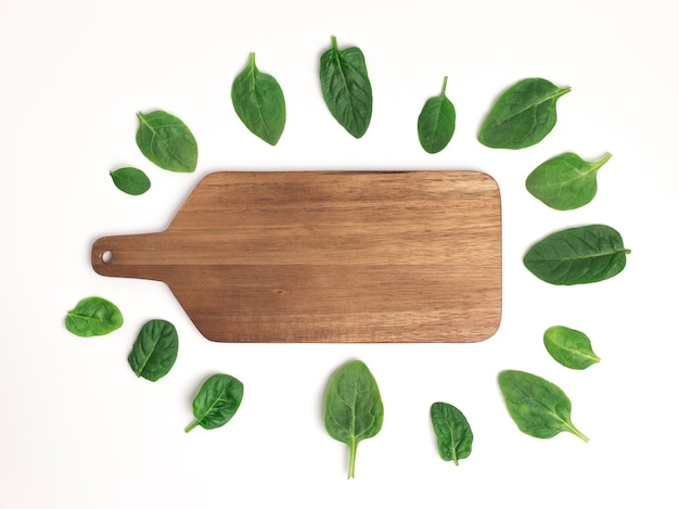 Cutting board with fresh spinach leaves, top view with copy space