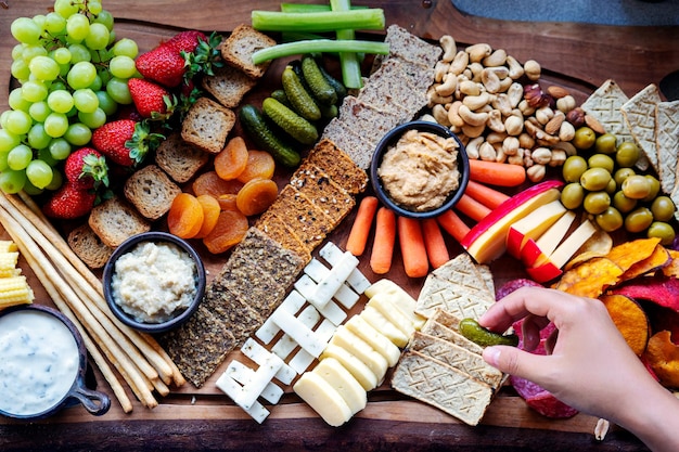 Cutting board with gourmet food fruits vegetables and cheese