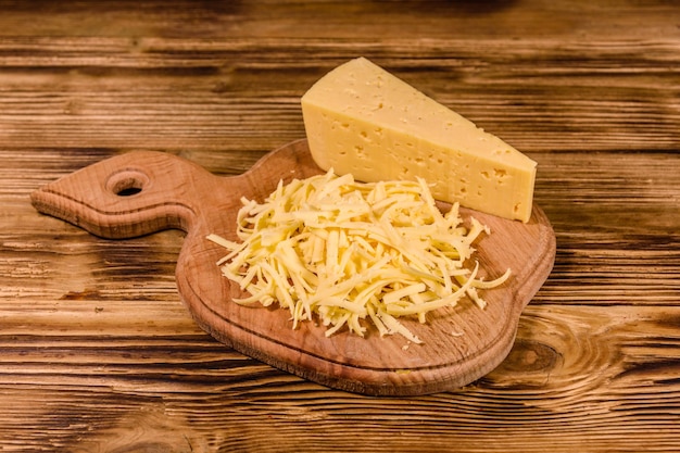 Cutting board with grated cheese on rustic wooden table