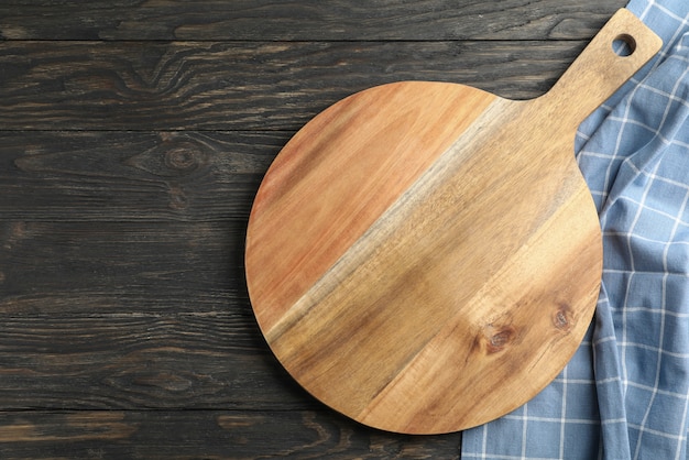 木製の背景、テキスト用のスペースにキッチンタオルでまな板