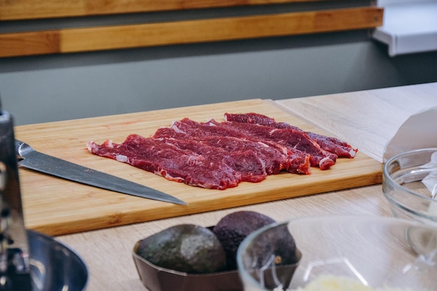 A cutting board with raw meat on it