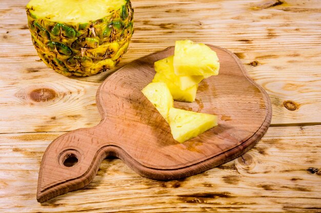 Cutting board with sliced pineapple on rustic wooden table