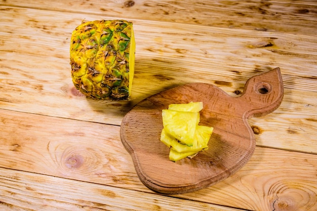 Cutting board with sliced pineapple on rustic wooden table