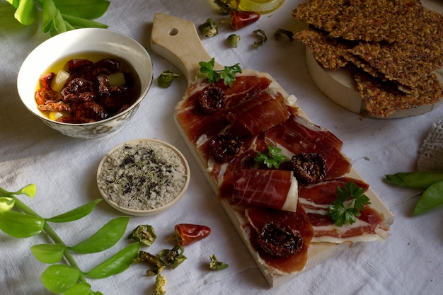 Photo a cutting board  with  traditional  tapas    with  spanish cured meat, sun dried tomato