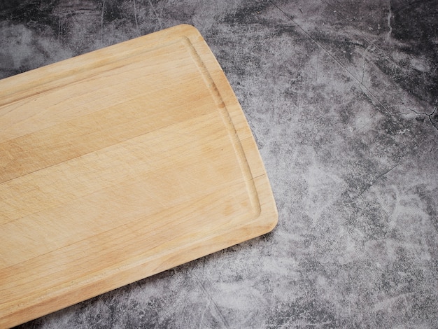 Cutting board wood on grey marble table.