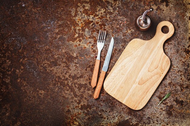 Cutting boards knife and fork on a rustic background