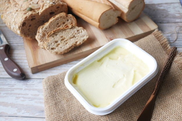 Cutting butter on chopping board and brown bread on surface