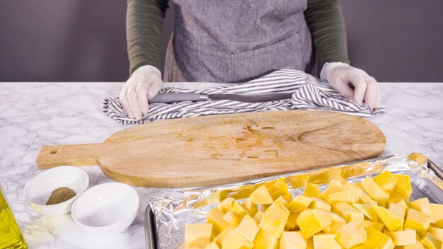 Cutting butternut squash on a wood cutting board.