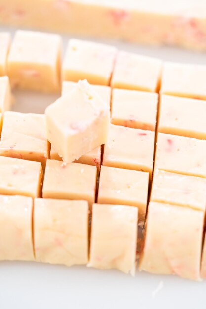 Cutting candy cane fudge into small cubes.